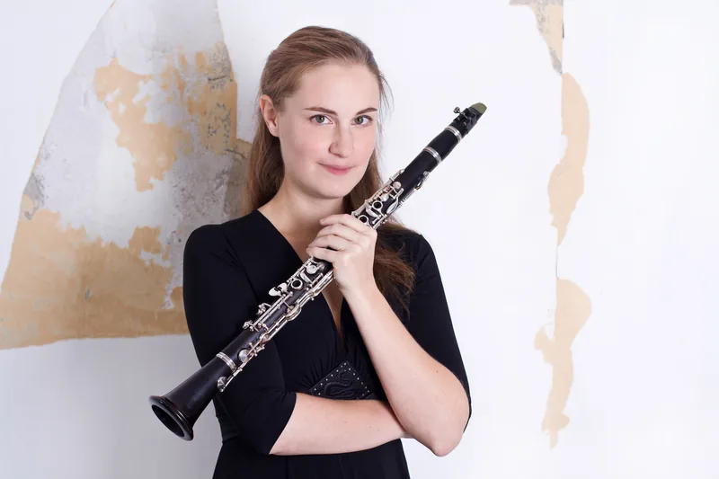 Friederike Roth mit Klarinette vor einer hellen Wand